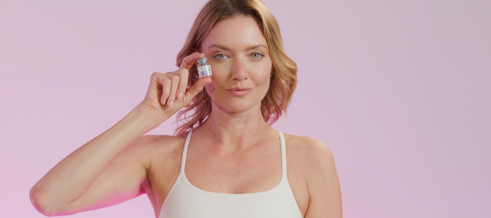 beautiful woman holding bottle of wrinkle relaxer to face