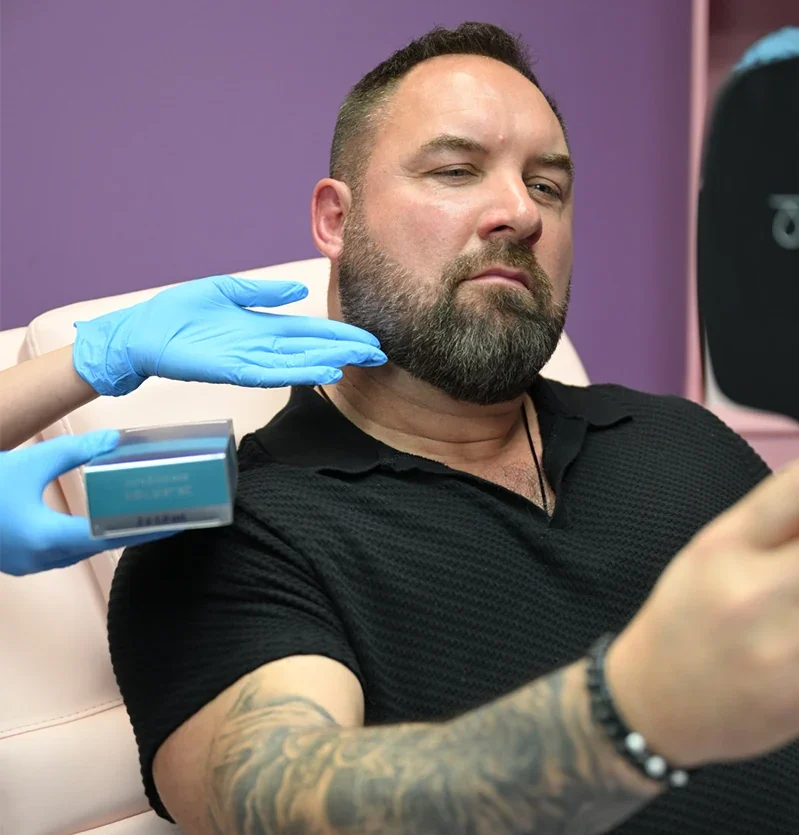 male dermfx client looking in mirror at injectable filler consult