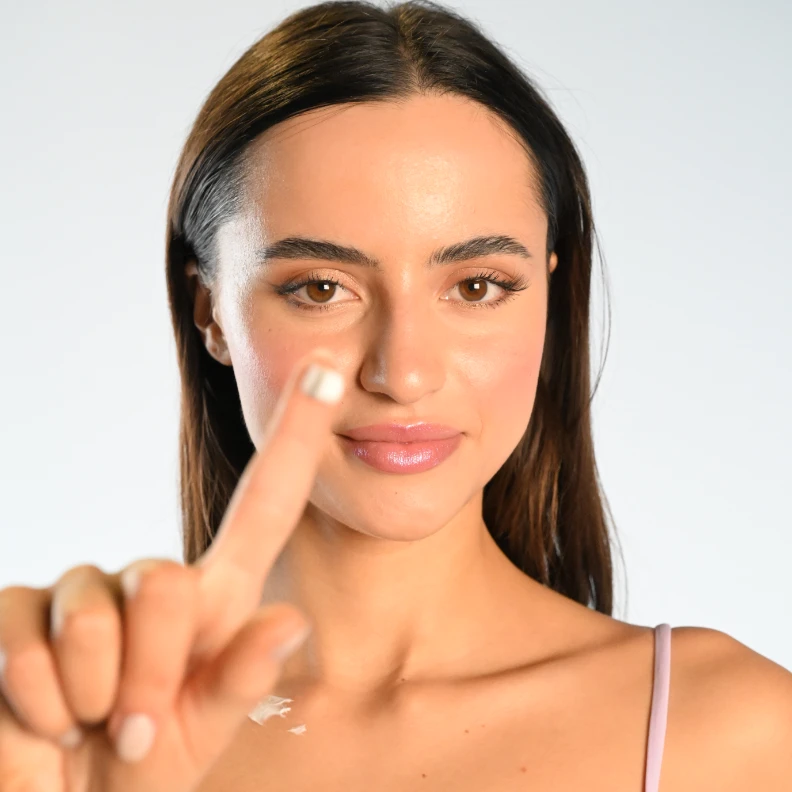 flawless-skinned woman with skincare product on finger