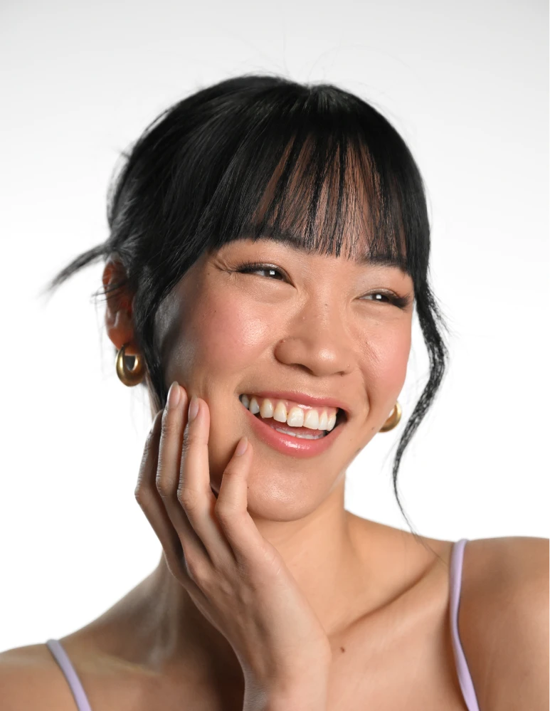 younger happy female client touching healthy, flawless skin