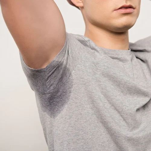 man with raised arm with sweat underarm